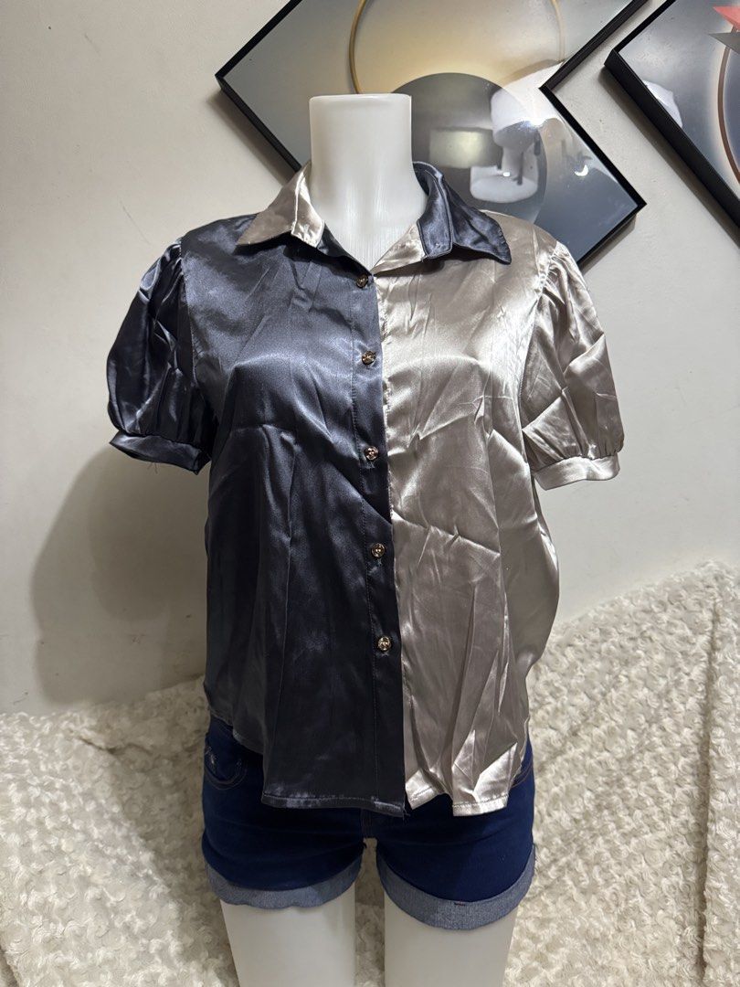 Two-tone Satin Short Sleeve Button-Down Blouse (Category: Blouses) located in Marikina City. Submitted by lorradel (Listing ID 1464905779, Image 1). Description: - Two-tone split design: dark grey and champagne gold - Short puff sleeves with comfortable elastic cuffs - Classic collared neck with chic gold-tone front buttons - Luxurious smooth satin fabric with a subtle sheen - Perfect for smart-casual or dressed-up looks - MAY HAVE some washable 