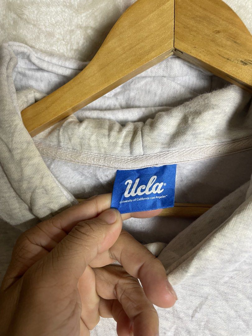 UCLA Light Grey Hoodie Sweatshirt (Category: Coats, Jackets and Outerwear) located in Molave. Submitted by charlesthrifter (Listing ID 1464896123, Image 2). Description: - Colour: Grey - Design: Small UCLA script logo embroidered on the chest - Features: Front kangaroo pocket, drawstring hood, and ribbed cuffs - Interior: Soft fleece lining for warmth and comfort - Vibe: Casual everyday sweatshirt, great for cooler weather.