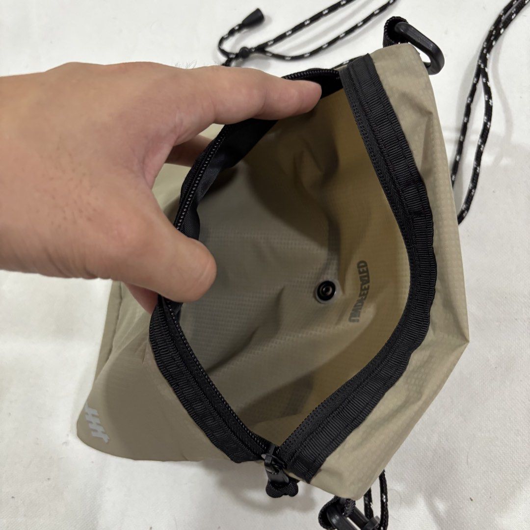 Undefeated Khaki Sling Bag with Mesh Pocket (Category: Sling Bags) located in Cavite. Submitted by itsayaaa (Listing ID 1464836894, Image 3). Description: - Undefeated crossbody bag in khaki and olive green mesh - Lightweight and durable ripstop material - Adjustable black rope shoulder strap with clips for a custom fit - Secure zippered main compartment - Front mesh pocket with snap button closure - Iconic white Undefeated logo printed near the 