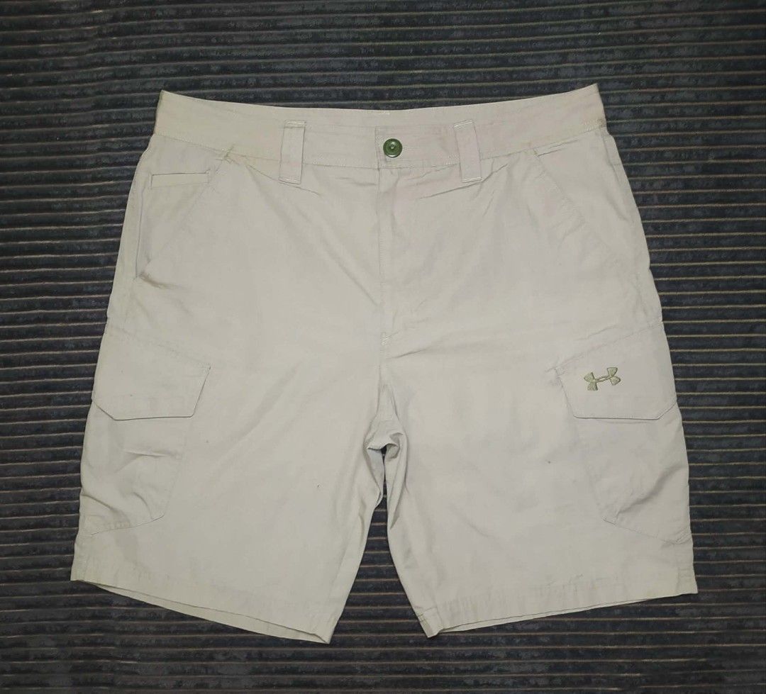 Under Armour Beige Cargo Shorts with Logo (Category: Shorts) located in Manila. Submitted by norathrifted (Listing ID 1464804451, Image 1). Description: - Brand: Under Armour - Color: Beige - Style: Cargo shorts with textured grid pattern - Storage: Multiple side and back pockets - Details: Button waist, sturdy belt loops, embroidered UA logos on leg and back pocket - Condition: Clean, excellent, and ready to wear.