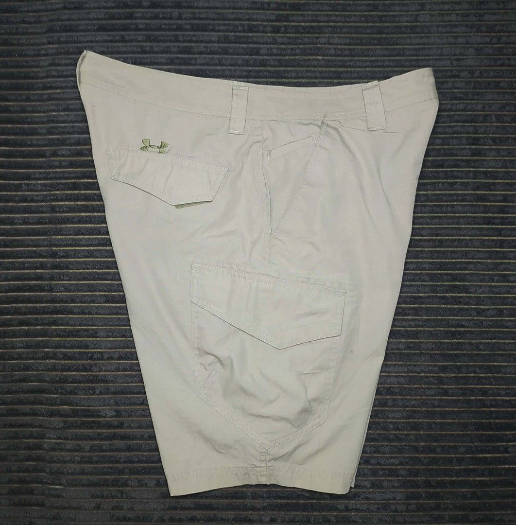 Under Armour Beige Cargo Shorts with Logo (Category: Shorts) located in Manila. Submitted by norathrifted (Listing ID 1464804451, Image 3). Description: - Brand: Under Armour - Color: Beige - Style: Cargo shorts with textured grid pattern - Storage: Multiple side and back pockets - Details: Button waist, sturdy belt loops, embroidered UA logos on leg and back pocket - Condition: Clean, excellent, and ready to wear.