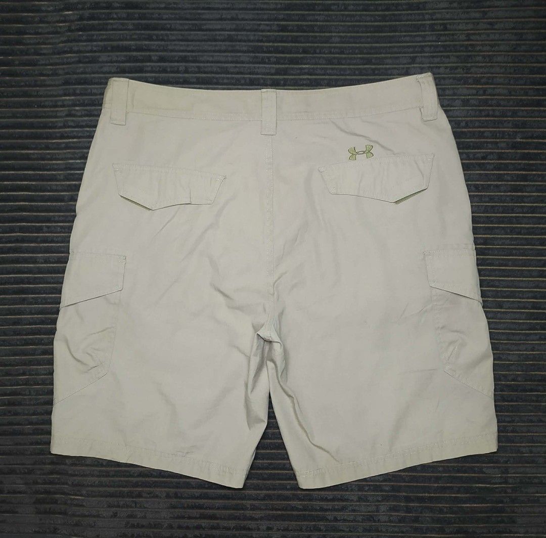 Under Armour Beige Cargo Shorts with Logo (Category: Shorts) located in Manila. Submitted by norathrifted (Listing ID 1464804451, Image 2). Description: - Brand: Under Armour - Color: Beige - Style: Cargo shorts with textured grid pattern - Storage: Multiple side and back pockets - Details: Button waist, sturdy belt loops, embroidered UA logos on leg and back pocket - Condition: Clean, excellent, and ready to wear.