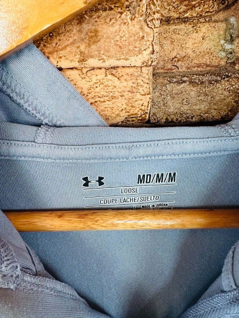 Under Armour Grey Half-Zip Hoodie Medium (Category: Hoodies) located in Santiago. Submitted by reyibanez253969 (Listing ID 1464909194, Image 2). Description: - Brand: Under Armour - Color: Grey with heathered lower half - Size: Medium (MD) - 21x27 - Design: Half-zip closure, adjustable hood, and black logo on the right chest - Fit: Relaxed loose fit with long sleeves - Origin: Made in Jordan - Condition/Use: Versatile layer ideal for workouts or 