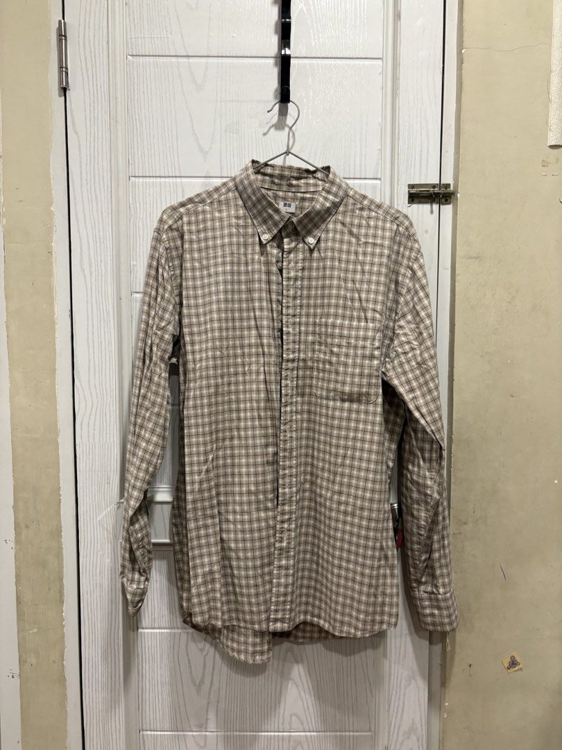 Uniqlo Plaid Button-Down Shirt Size L (Category: Tshirts & Polo Shirts ) located in Mandaluyong City. Submitted by shopwithjuu (Listing ID 1464781054, Image 1). Description: Uniqlo long sleeve plaid shirt in beige, white, and dark blue, size Large. Features a button-down collar, chest pocket, and adjustable cuffs. A versatile casual staple that pairs easily with jeans or chinos..