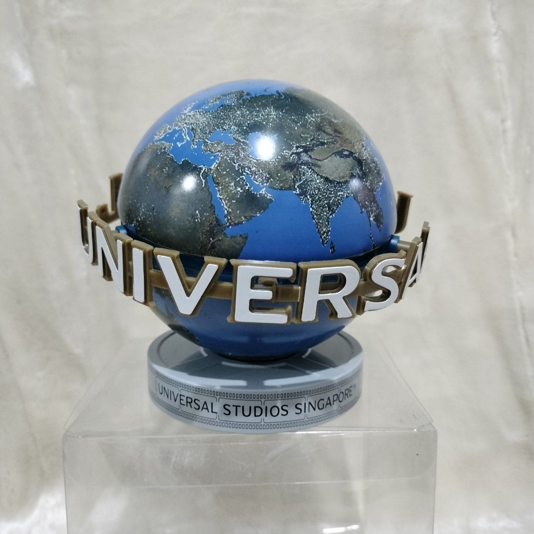 Universal Studios Singapore Souvenir Globe Cookie Tin Container (Category: Figurines & Statues) located in Imus. Submitted by viaysthriftshop (Listing ID 1464877524, Image 3). Description: ▪️Official Universal Studios Singapore merchandise ▪️New, unused item with slightly dented clear plastic display box ▪️Cookie Tin can container ▪️Height: 5.5 inches ▪️Features the iconic revolving-style globe design with the Universal logo ring 𝗠𝗢𝗣 ▪️GCash @