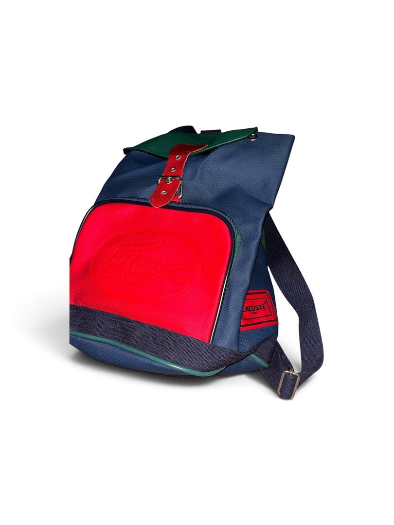 Vintage Chemise Lacoste Backpack (Category: Backpacks) located in Nabua. Submitted by lastthrift2.0 (Listing ID 1464960284, Image 3). Description: Issue•Check last photo Plus sf - Vintage Chemise Lacoste colorblock backpack (navy, green, and red) - Large debossed crocodile logo on the front pocket - Secure drawstring main closure under a buckled flap - Durable adjustable canvas shoulder straps - Classic Chemise Lacoste interior branding tag - Rar