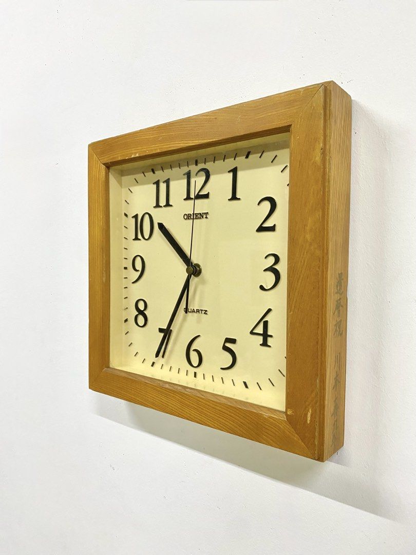 Vintage Orient Wooden Square Wall Clock (Category: Clocks) located in Santa Rosa. Submitted by annie_annie83 (Listing ID 1464874050, Image 2). Description: - Brand: Orient - Type: Square wooden wall clock - Movement: Quartz (battery-operated) - Design: Off-white face with classic black Arabic numerals - Unique feature: Japanese kanji inscription stamped on the wooden side panel - Condition: Wooden frame shows minor surface wear from previous hang
