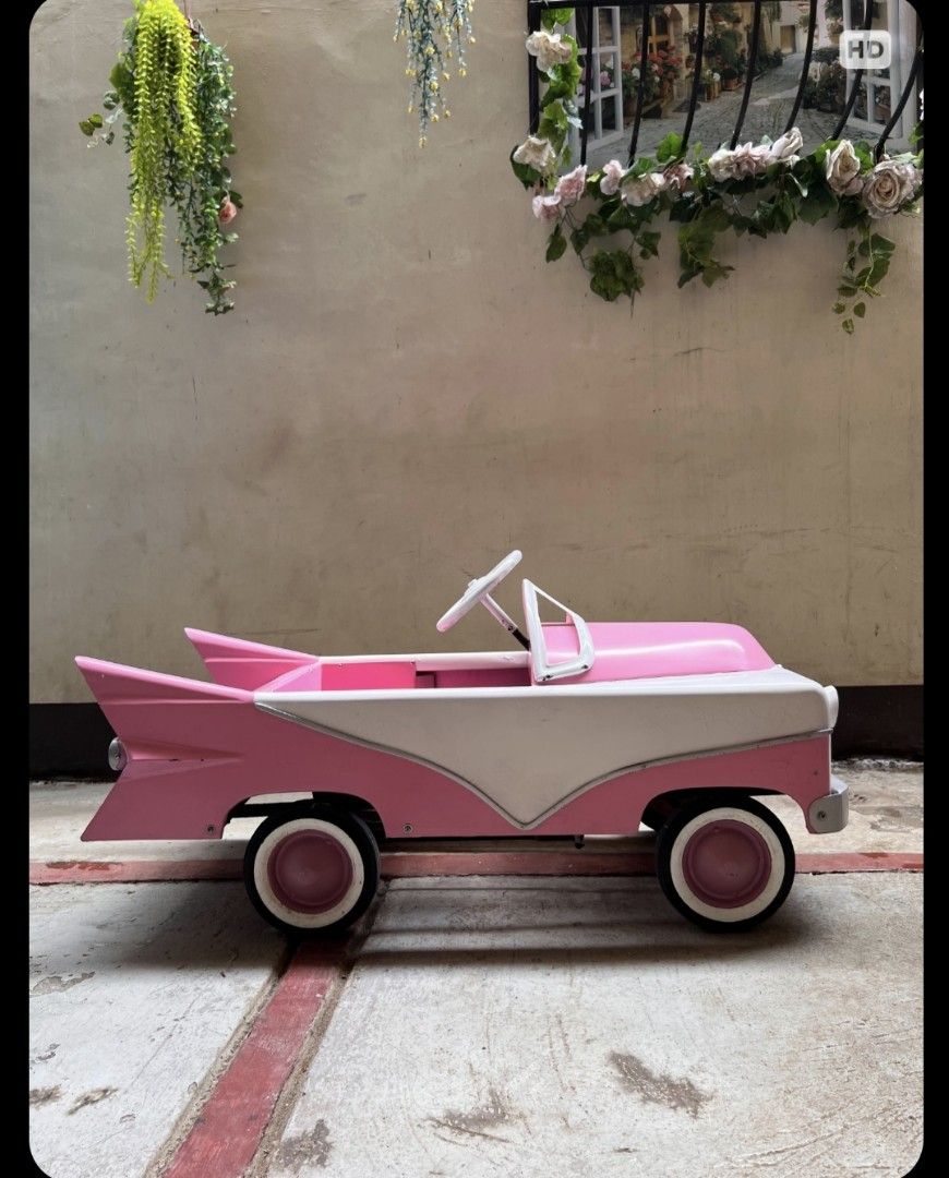 Vintage pedal car (Category: Kids Toys) located in Mandaluyong City. Submitted by LEATHERFACE (Listing ID 1464794576, Image 1). Description: - Vintage 1950s design featuring classic tailfins and a stylish pink and white finish - Sturdy metal construction complete with detailed front grille and matching steering wheel - Authentic white-walled wheels for that timeless retro look - Versatile use as a stunning display piece or a fun kid's ride-on - C