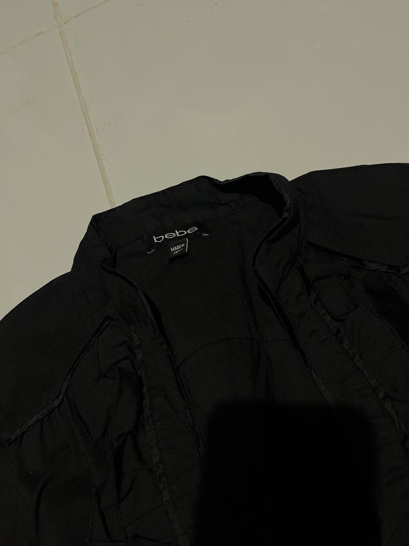 Vintage Y2K Goth bebe black button-up blouse (Category: Blouses) located in Paranaque City. Submitted by flees.thrift10 (Listing ID 1464901164, Image 2). Description: It features a plunging V-neckline framed with tiered ruffle trim, a structured panel waist, and short cap ruffle sleeves..