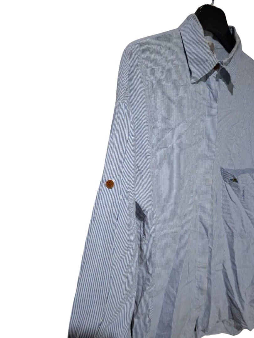 Vivienne Westwood (Category: Blouses) located in San Juan (Cabalian). Submitted by ec8thrift (Listing ID 1464904362, Image 3). Description: - Vivienne Westwood London button-up shirt - Classic blue and white stripe pattern - Long sleeves with convenient tab rolls - Features a single chest pocket with embroidered orb logo detail - Brown front button closure - Cut washtag.