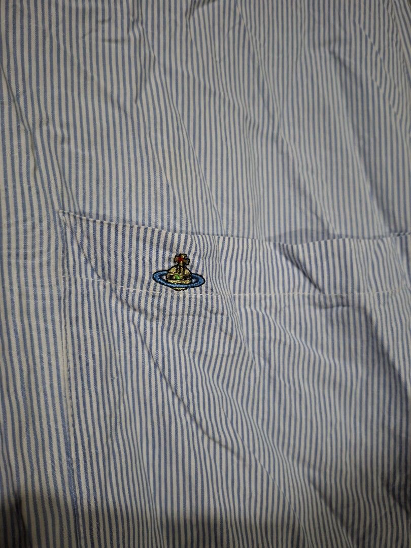 Vivienne Westwood (Category: Blouses) located in San Juan (Cabalian). Submitted by ec8thrift (Listing ID 1464904362, Image 2). Description: - Vivienne Westwood London button-up shirt - Classic blue and white stripe pattern - Long sleeves with convenient tab rolls - Features a single chest pocket with embroidered orb logo detail - Brown front button closure - Cut washtag.