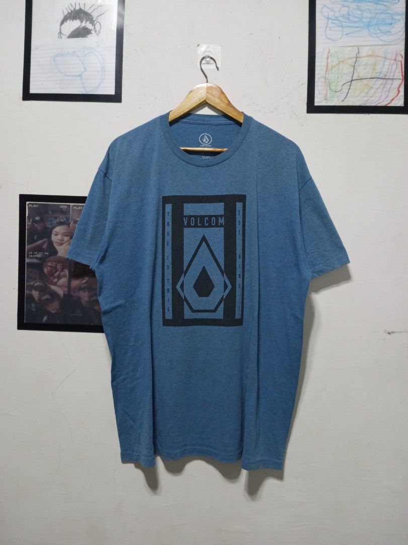 Volcom Blue Graphic Tee Size 2XL (Category: Tshirts & Polo Shirts ) located in Magdalena. Submitted by magdalenathrift20 (Listing ID 1464911067, Image 2). Description: - Brand: Volcom - Size: 2XL (26" chest width, 31" length) - Design: Blue heather with large chest graphic print, crew neck, short sleeves - Material: Comfortable standard cotton blend - Condition: Great for casual everyday wear.