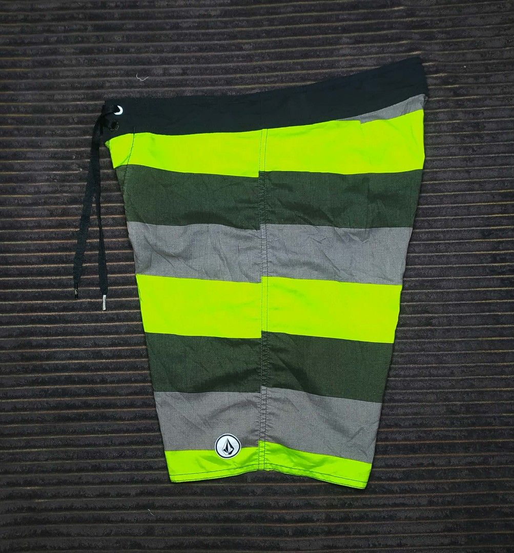 Volcom Men's Striped Board Shorts Swim Trunks (Category: Swim Trunks & Board Shorts) located in Manila. Submitted by norathrifted (Listing ID 1464797598, Image 3). Description: - Brand: Volcom - Design: Horizontal stripes in green, grey, and neon yellow - Waistband: Black with adjustable drawstring and branded metal aglets - Pockets: Single back pocket with flap and button closure - Details: Volcom logo patches on the front leg and back pocket - 