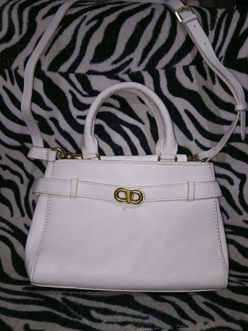 White handbag with top handle and crossbody strap (Category: Shoulder Bags) located in Valenzuela. Submitted by rowenasalvador777 (Listing ID 1464968025, Image 1). Description: - Color: Clean white - Style: Structured everyday handbag with elegant gold-tone hardware and belt detail - Versatile: Includes top handles and a long adjustable shoulder strap - Capacity: Perfectly fits your daily essentials like phone, wallet, and keys - Quality: Neat, c