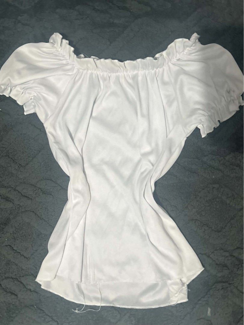 White Off-Shoulder Ruffle Top Peasant Blouse (Category: Blouses) located in Manila. Submitted by yaycockroach (Listing ID 1464852623, Image 1). Description: - Color: White - Design: Off-shoulder with ruffled elastic neckline and short puffed sleeves - Silhouette: Cinched waist for a flattering fit - Material: Soft, silky fabric with a smooth finish - Flaw: Loose threads hanging on one side of the hem - Styling: Perfect to pair with skirts or high