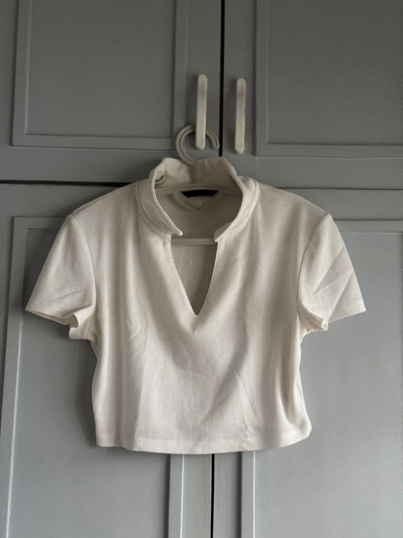 White ribbed crop top with v-neck collar (Category: Sleeveless) located in Rizal. Submitted by yowfaveariesdeclutter (Listing ID 1464867720, Image 1). Description: - Color: White - Material: Stretchy ribbed knit fabric for ultimate comfort - Design: Short sleeves, mock neck, and trendy deep V-cut neckline cutout - Fit: True to size, flattering crop top length - Styling: Great basic piece; easily pairs with high-waisted jeans or skirts for a daily