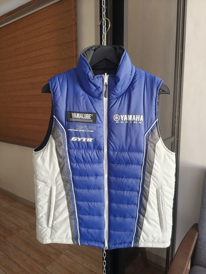 Yamaha Racing Reversible Vest (Category: Vests) located in Siniloan. Submitted by wingedwardrobe (Listing ID 1428695433, Image 1). Description: 21x24 Size L Excellent condition, no issue Reversible vest featuring a black side and a blue Yamaha Racing design. It has a full-length zipper and a stand-up collar. The blue side has Yamaha Racing branding on the chest. It is sleeveless and suitable for layering. 𝓐𝓵𝓵 𝓲𝓽𝓮𝓶𝓼 𝓪𝓻𝓮 𝓾𝓷𝔀𝓪𝓼𝓱𝓮𝓭