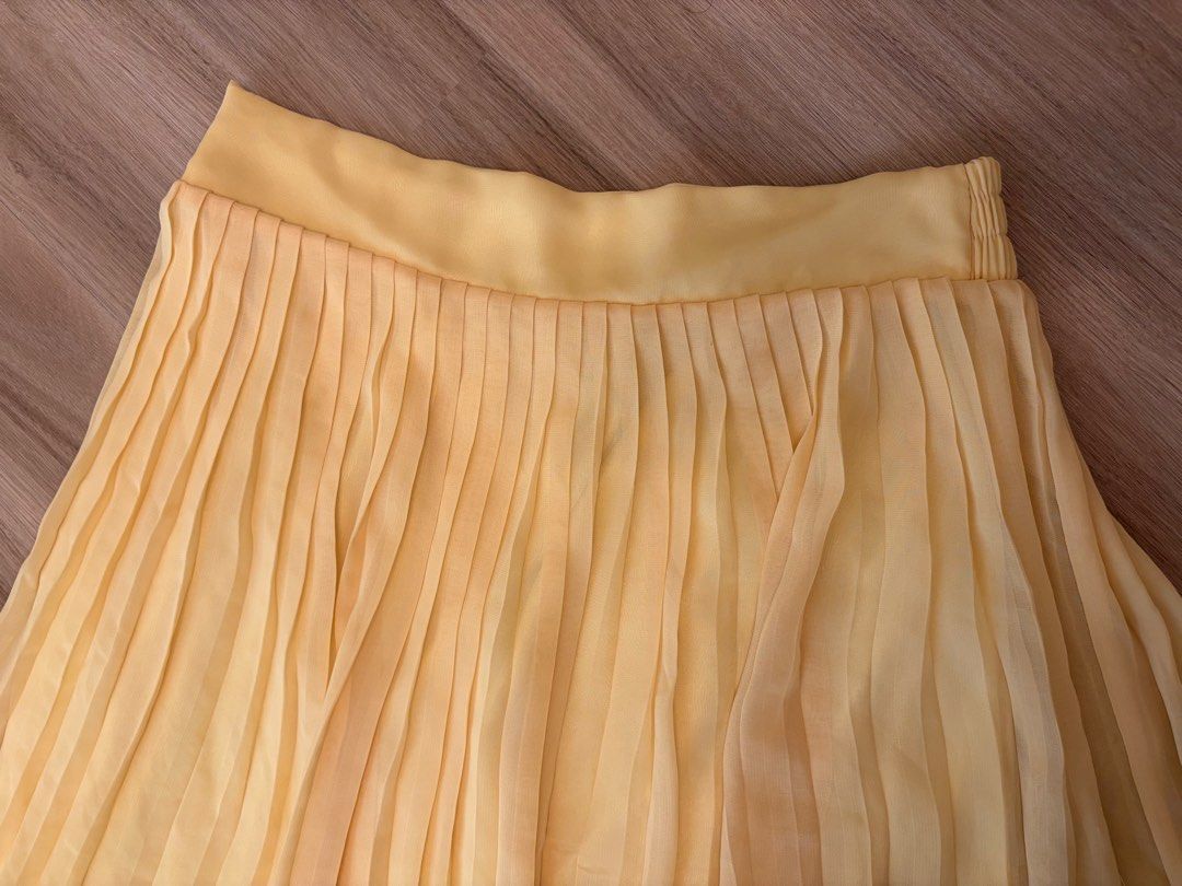 Yellow Pleated Chiffon Skirt (Category: Skirts) located in Manila. Submitted by ele.ele (Listing ID 1464804266, Image 3). Description: - Bright yellow pleated chiffon skirt - Comfy elastic waistband for an easy fit - Lightweight, layered fabric with a nice flow - Perfect staple piece to pair with basic tees or blouses - Ideal for sunny days - Fits small - Minor stain on upper left side but barely noticeable (highlighted in photo).