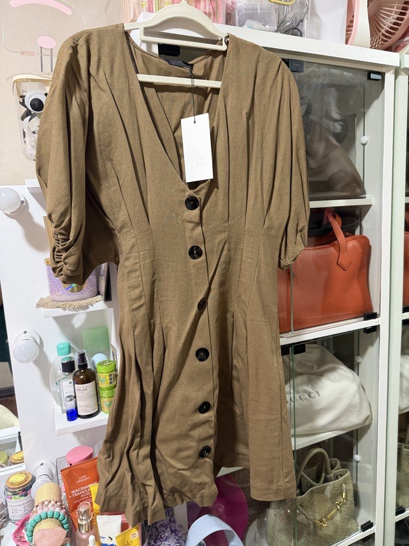 Zara Brown Button-Front Dress Size S (Category: Dresses) located in Manila. Submitted by madsdedios05212 (Listing ID 1464778118, Image 3). Description: - Brand: Zara - Size: Small (Tag still attached) - Original Price: 2,795 PHP - Color: Brown - Details: Short puffed sleeves, V-neckline, large black front buttons, and a fitted waist with subtle pleating - Condition: Brand new with tags.