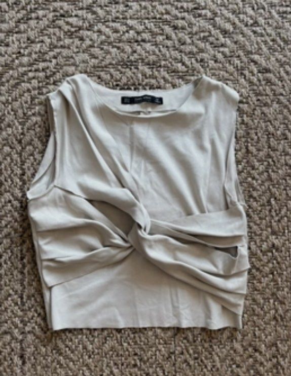 Zara sleeveless draped twisted crop top beige (Category: Sleeveless) located in Manila. Submitted by itsarah (Listing ID 1464843070, Image 2). Description: - Brand: Zara - Style: Sleeveless crop top with twisted front drape detail - Color: Beige - Neckline: Round neckline with a straight hem - Material: Lightweight fabric, ideal for warm weather or layering.