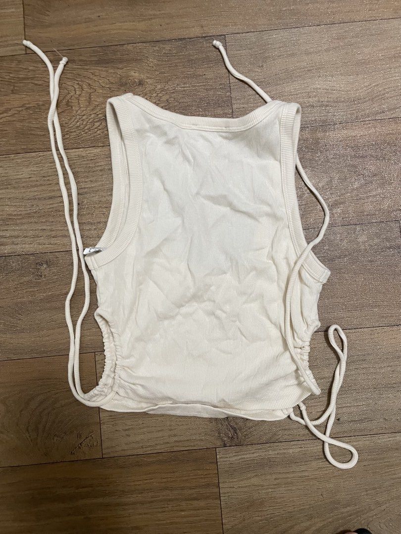 Zara White Ribbed Side Ruched Tie Tank Top (Category: Sleeveless) located in Manila. Submitted by seasellsclset (Listing ID 1464798575, Image 2). Description: - Brand: Zara - Color: Off-white - Style: Scoop neck ribbed tank top with regular fit - Feature: Adjustable side drawstrings with ties for a custom ruched look - Material: Lightweight cotton blend - Condition/Use: Perfect basic piece for layering or pairing with high-waisted denim - fits xs