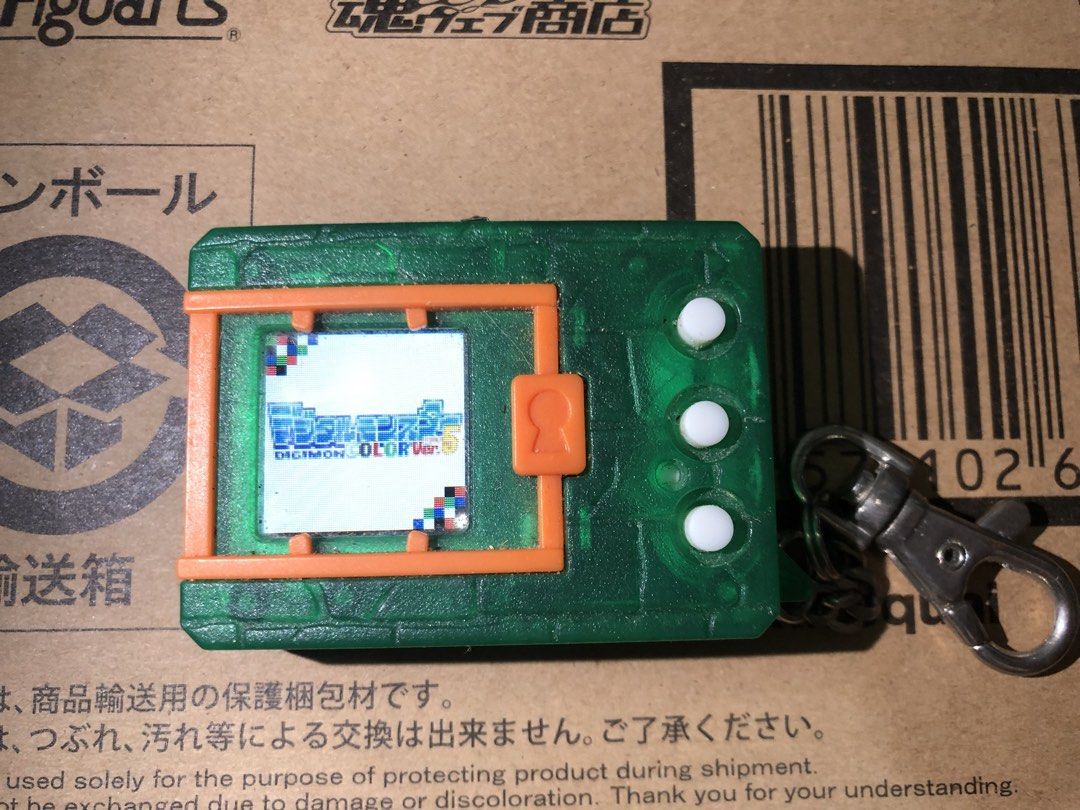 彩色數碼暴龍機 ver.5 （分類：互動玩具）位於 Hong Kong。 由 yuki_ng_ 提交（商品編號 1459388255，圖片 1）。簡介： 數碼寶貝機，Digimon ver.5。綠色半透明外殼，橙色邊框。有掛繩扣。機身有三個白色按鈕。屏幕顯示數碼寶貝標誌。懷舊經典玩具，適合收藏或送禮。。