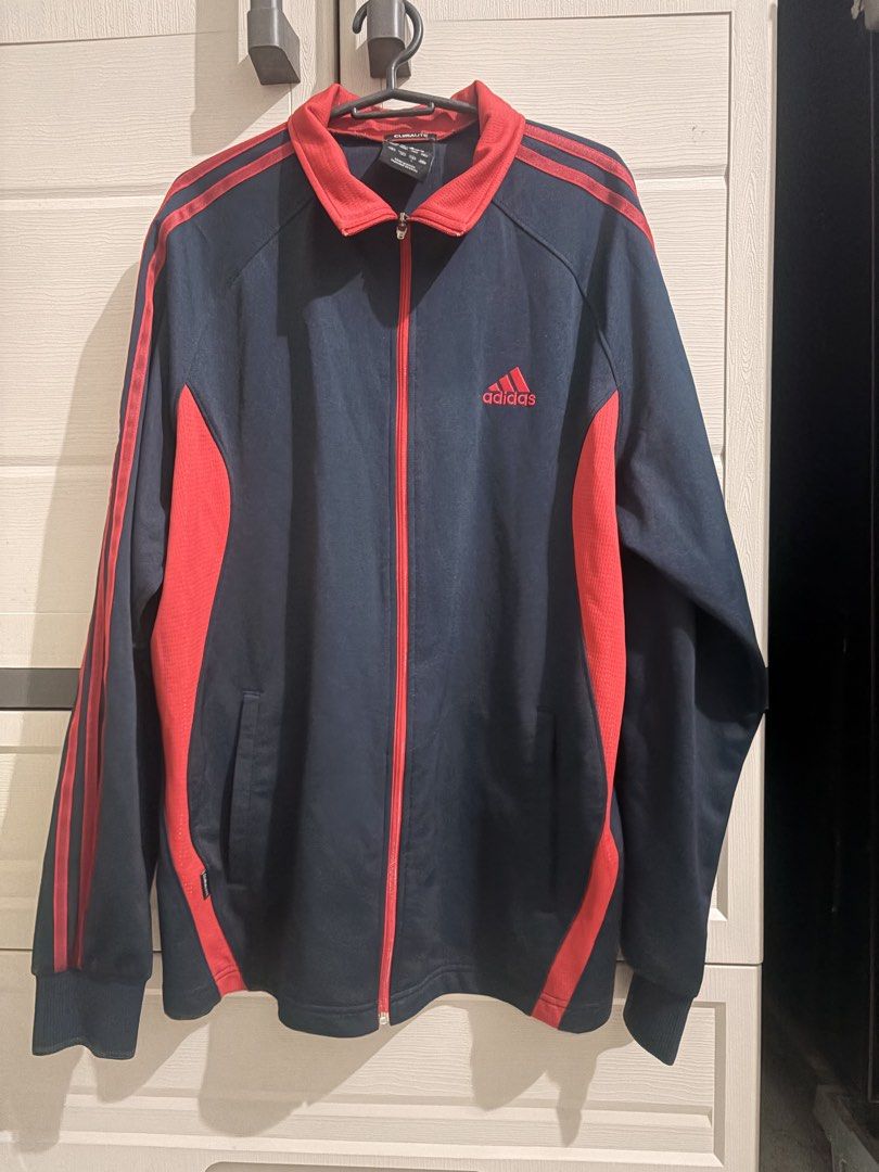 Adidas Climalite Track Jacket Navy Blue Red (Category: Coats, Jackets and Outerwear) located in Manila. Submitted by athenabrave (Listing ID 1459319613, Image 1). Description: - Classic Adidas track jacket - Navy blue with red accents and stripes - Features Adidas logo on chest - Made with Climalite material for comfort - Full zip closure - Ideal for sports or casual wear.