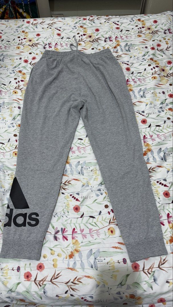 Men’s Adidas Grey Jogger Sweatpants (Category: Joggers) located in Taguig. Submitted by decluttering.v.2.0 (Listing ID 1459421332, Image 2). Description: - Grey Adidas sweatpants - Size: A/M - Elastic waistband with drawstring - Ribbed cuffs - Large black Adidas logo on left leg - Ideal for lounging or workouts.