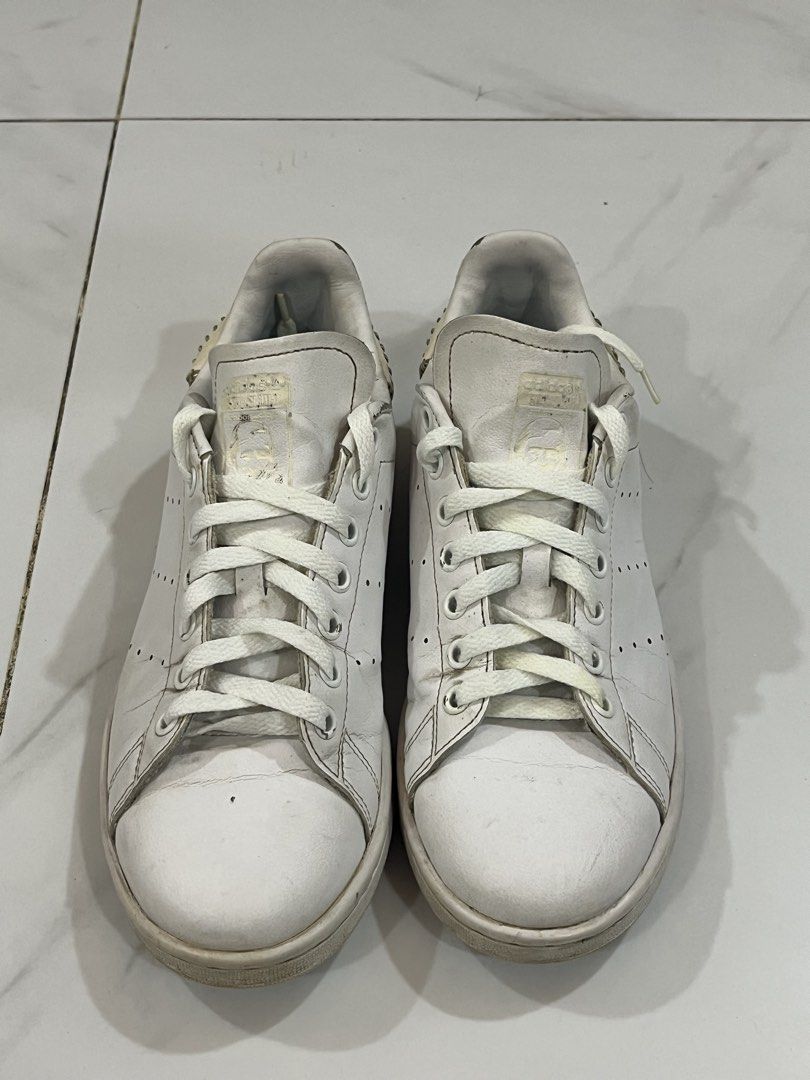 Adidas Stan Smith White Leather Sneakers (Category: Sneakers) located in Manila. Submitted by mikeezs (Listing ID 1459335167, Image 1). Description: - Classic white Adidas Stan Smith sneakers - Genuine leather upper - Signature perforated 3-Stripes detail - Lace-up closure - Shows some signs of wear on leather and soles - Still a great pair for everyday wear - Size: 8 US - insoles broken.