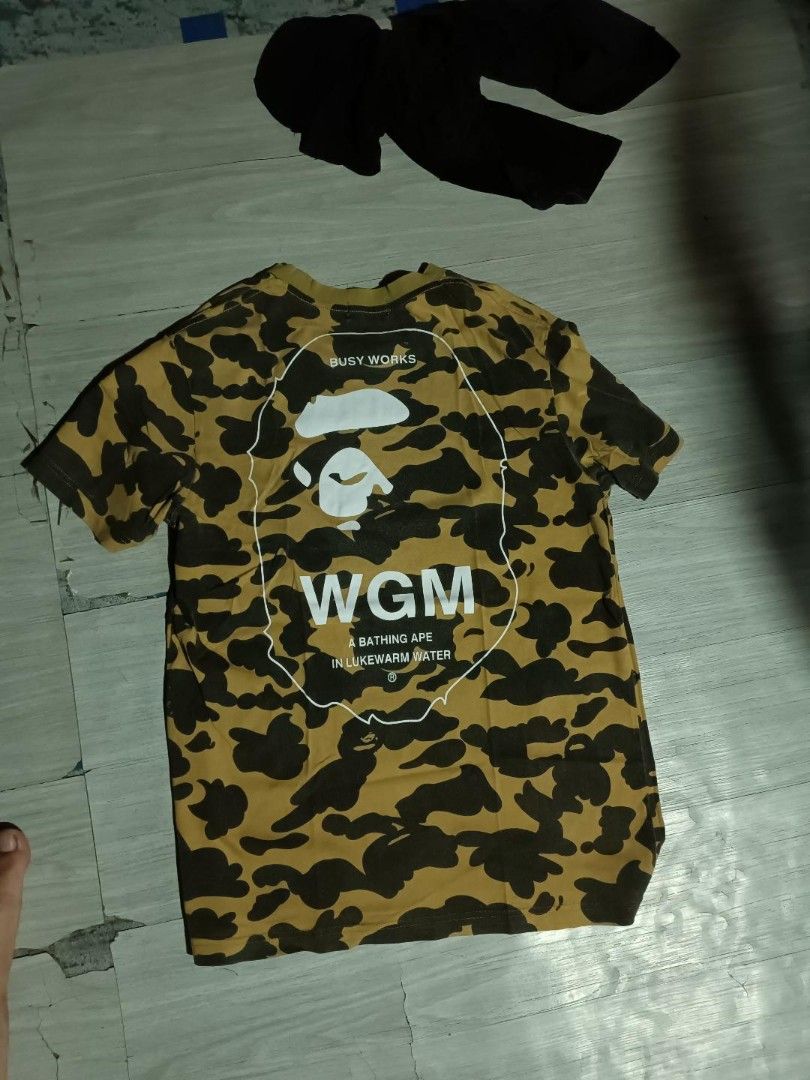 BAPE WGM Busy Works Camo Tee (Category: Tshirts & Polo Shirts ) located in Manila. Submitted by jhonkenagu57088 (Listing ID 1459396046, Image 1). Description: - Authentic BAPE tee - Eye-catching yellow and black camouflage pattern - Features iconic WGM Busy Work graphic on the back - Classic short sleeves and crew neck design - Ideal for everyday casual wear.