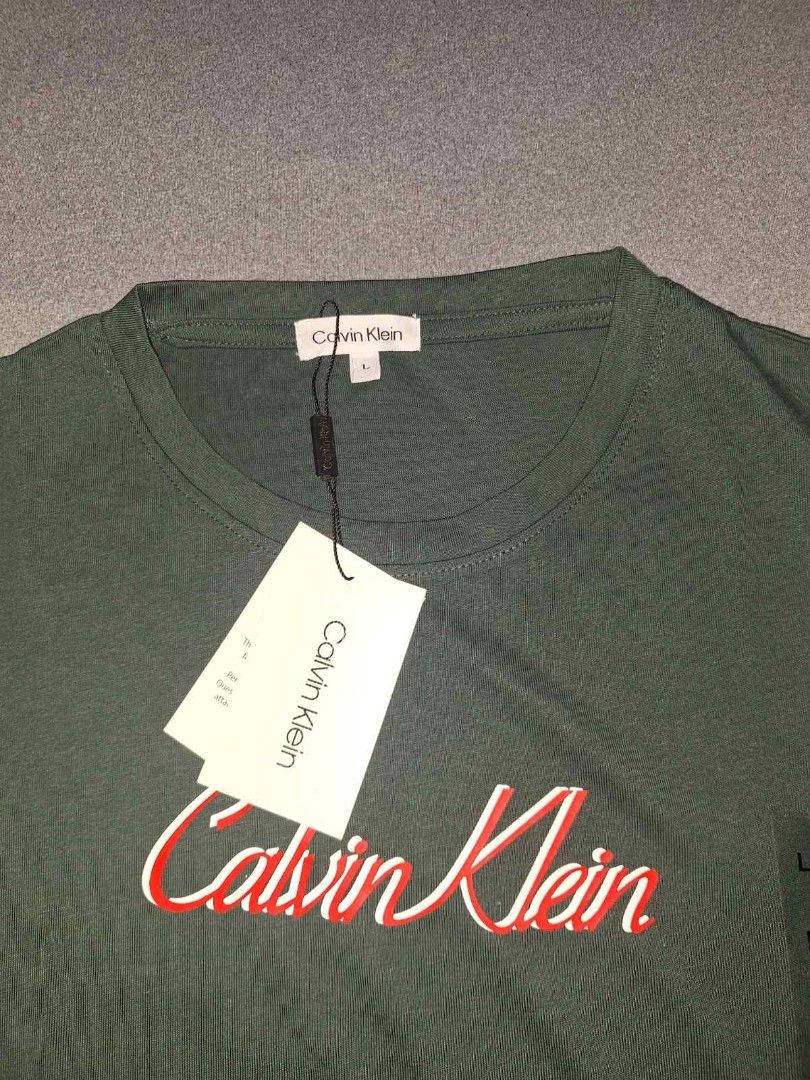 Calvin Klein T-Shirts - White & Green (Category: Shirts) located in Taguig. Submitted by chloe_clothingco. (Listing ID 1459437597, Image 3). Description: - brand new Calvin Klein t-shirts - Size: Large (L) and med - Color 1: White with blue CK logo - Color 2: Dark green with red and white script logo - Both shirts have original tags still attached - Excellent basic pieces for everyday wear.