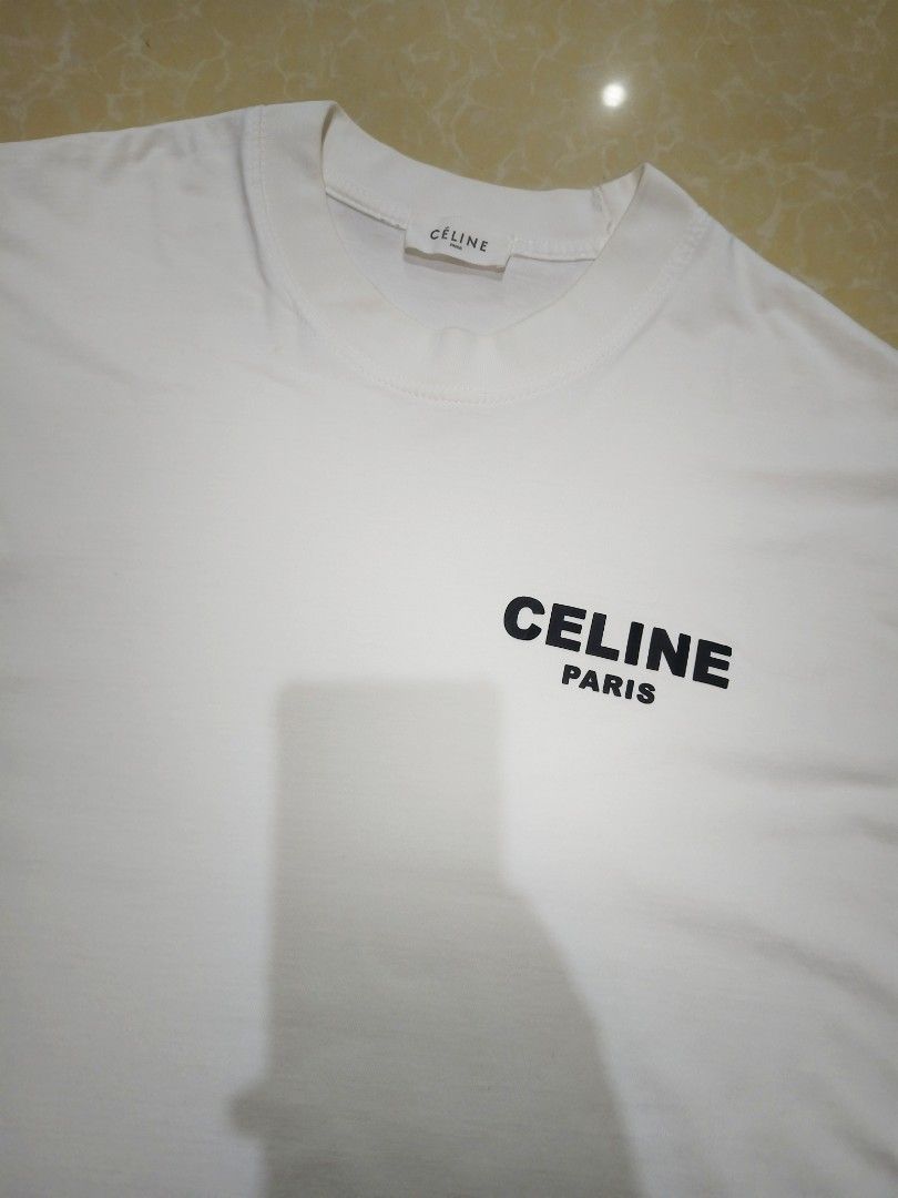Celine Paris White T-Shirt (Category: Tshirts & Polo Shirts ) located in Manila. Submitted by purefire-477a (Listing ID 1459352455, Image 3). Description: - Authentic Celine Paris White T-shirt - Features the signature Celine logo on both the front and back - Size: 22 inches width x 29 inches length - Condition: Excellent, rated 9.5/10 for color vibrancy - A perfect staple piece for effortless style and comfort.