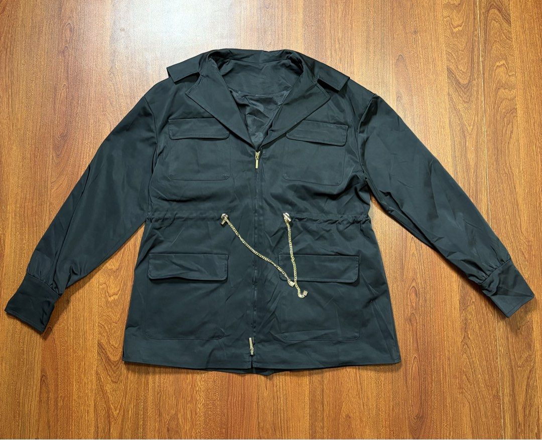 CHANNEL BOUTIQUE SERIES TECHNICAL WORK JACKET (Category: Coats, Jackets and Outerwear) located in Cavite. Submitted by frankiemnla (Listing ID 1459322008, Image 1). Description: L- 27.5 W- 21 Size- Med to Large Design: A black, lightweight utility or windbreaker silhouette featuring a zip-front closure, structured wide collar, and four prominent front utility flap pockets. Hardware: The waist features a distinct gold-tone metal interwoven chain-l