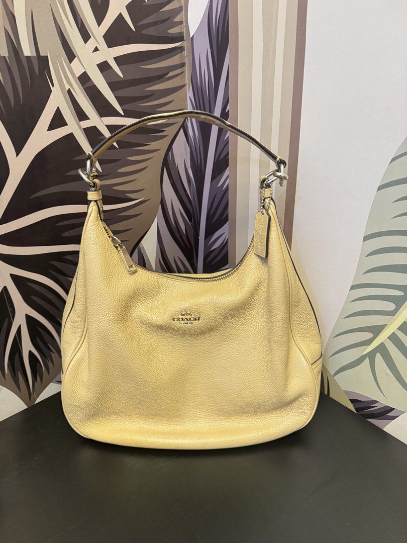 Coach Pebble Leather Hobo Shoulder Bag (Category: Luxury Bags & Wallets) located in Manila. Submitted by abieebey (Listing ID 1459401514, Image 2). Description: - Light yellow Coach hobo bag - Made from durable pebble leather - Features elegant silver hardware - Secure zipper closure - Spacious interior for all your essentials - Comes with the iconic Coach hangtag - Ideal for everyday wear.