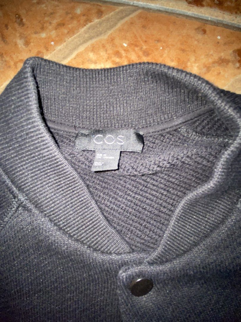 COS Black Bomber Jacket (Category: Coats, Jackets and Outerwear) located in Manila. Submitted by bravecloud.304b93 (Listing ID 1459490760, Image 3). Description: - Brand: COS - Color: Black - Style: Bomber Jacket - Closure: Button-up front - Features: Ribbed collar, cuffs, and hem - Design: Simple and classic - Versatility: Great for casual wear and layering.