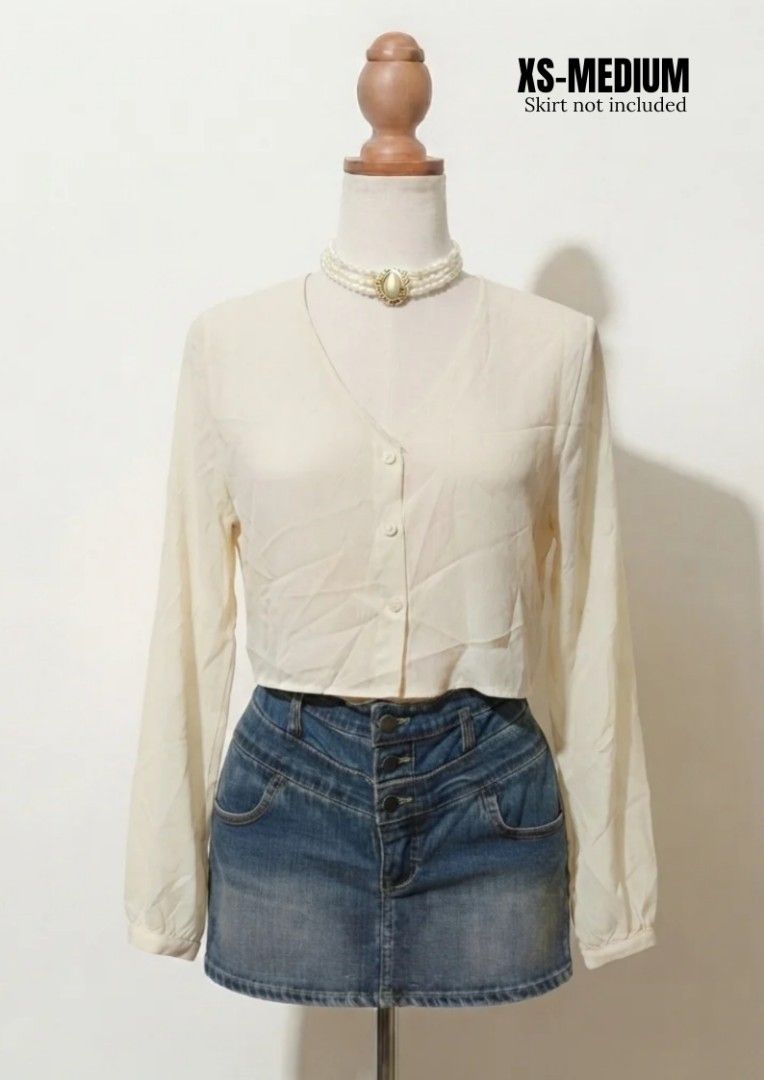 Cream V-Neck Cropped Long Sleeve Blouse (Category: Blouses) located in Vintar. Submitted by roweeflores.flowerpower (Listing ID 1459351459, Image 1). Description: - Cream colored blouse - V-neckline - Button-up front - Cropped length - Long sleeves - Lightweight material - Fits XS to Medium - Skirt shown is not included.