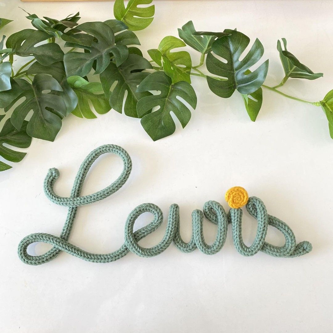 Custom Crocheted Name Sign Wall Art (Category: Handmade Craft) located in Mandaue City. Submitted by zenstone.1367ac (Listing ID 1459371226, Image 1). Description: - Handmade crocheted name signs - Perfect for nursery decor or personalized gifts - Available in various colors - Custom names welcome - Each letter is carefully crafted - Adds a unique touch to any room - Message for custom orders and pricing.