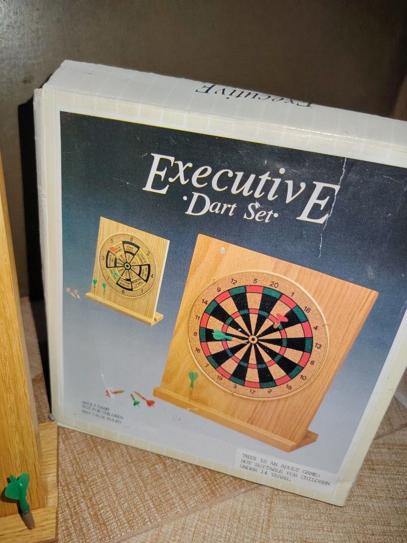 Executive Dart Set with Wooden Stand and Darts (Category: Action & Battle Toys) located in Santiago. Submitted by aceheart0118672 (Listing ID 1459293892, Image 2). Description: - Executive Dart Set with a stylish wooden stand. - Comes with a dartboard featuring a fun office-themed side (e.g., 'Fire Someone', 'Go on Vacation'). - Includes four darts: two red and two green. - Box is included for convenient storage or gifting. - Ideal for adding a t