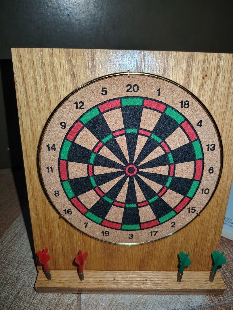 Executive Dart Set with Wooden Stand and Darts (Category: Action & Battle Toys) located in Santiago. Submitted by aceheart0118672 (Listing ID 1459293892, Image 3). Description: - Executive Dart Set with a stylish wooden stand. - Comes with a dartboard featuring a fun office-themed side (e.g., 'Fire Someone', 'Go on Vacation'). - Includes four darts: two red and two green. - Box is included for convenient storage or gifting. - Ideal for adding a t