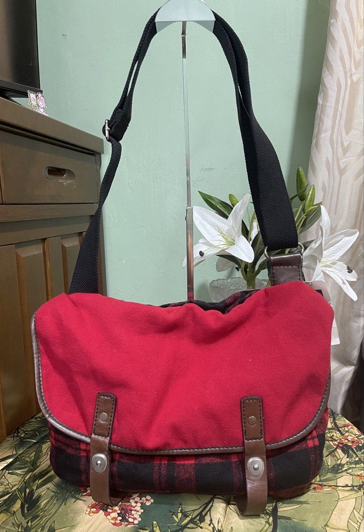 Gap Red Plaid Messenger Bag (Category: Sling Bags) located in Davao. Submitted by hiedelle1120 (Listing ID 1459482810, Image 1). Description: - Red and black plaid messenger bag from Gap - medium to large size - Durable canvas material with faux leather trim - Adjustable strap for comfortable wear - Interior zip pocket for secure storage - Ideal size for everyday essentials - Interior is clean and well-maintained.