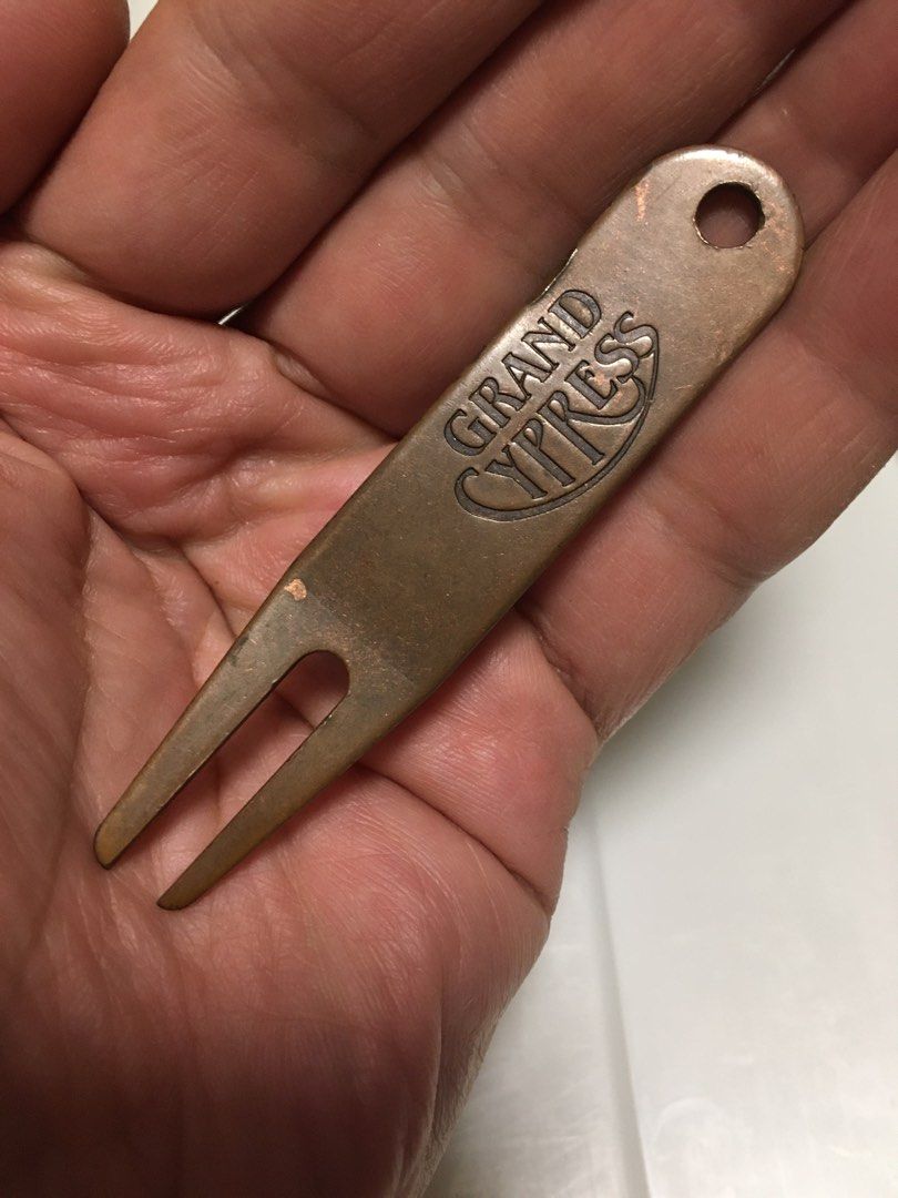 Grand Cypress Golf Divot Repair Tool (Category: Other Sports Equipment and Supplies) located in Pasay City. Submitted by gilbertso62551 (Listing ID 1459409228, Image 3). Description: - Bronze colored golf divot tool - Features embossed 'Grand Cypress' logo - Small hole for keychain or bag attachment - Essential accessory for golfers - As is,where is.