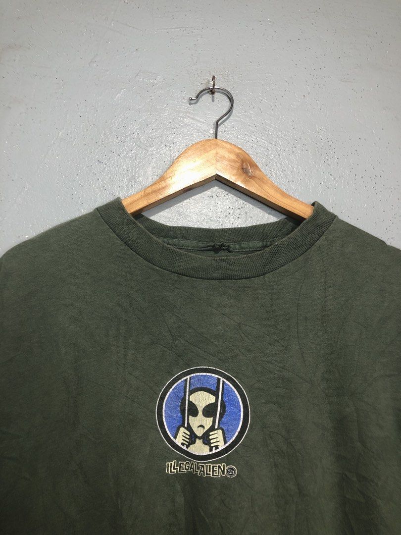 Illegal Alien Graphic T-Shirt (Category: Tshirts & Polo Shirts ) located in Bacong. Submitted by crommermann (Listing ID 1459430052, Image 2). Description: Allien tee 🏷️ + 90 shipping fee -Dimes Width 23 Length 29 -Condition 9/10 -Color Rate 9.5/10 Good Condition Color may vary due to lightning Very Presentable when Worn Issue can be seen in the pictures Need Wash Pm/Dm Visayas Dumaguete loc J&T Courier Express 🚛🚛🚛 .