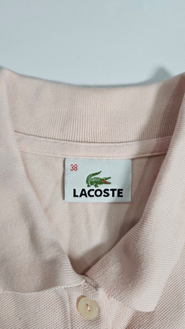 Lacoste polo shirt (Category: Others Tops) located in Alfonso. Submitted by jbcamet (Listing ID 1459334833, Image 3). Description: - Brand: Lacoste - Type: Polo Shirt - Color: Pastel Pink - Size: 38 (EU/UK 10/US 6/Medium) - Features: Embroidered Lacoste crocodile logo, buttoned placket - Material: Likely cotton blend (typical for Lacoste polos, check care tag for specifics) - Condition: Excellent, pre-loved - Style: Classic, versatile, smart casu