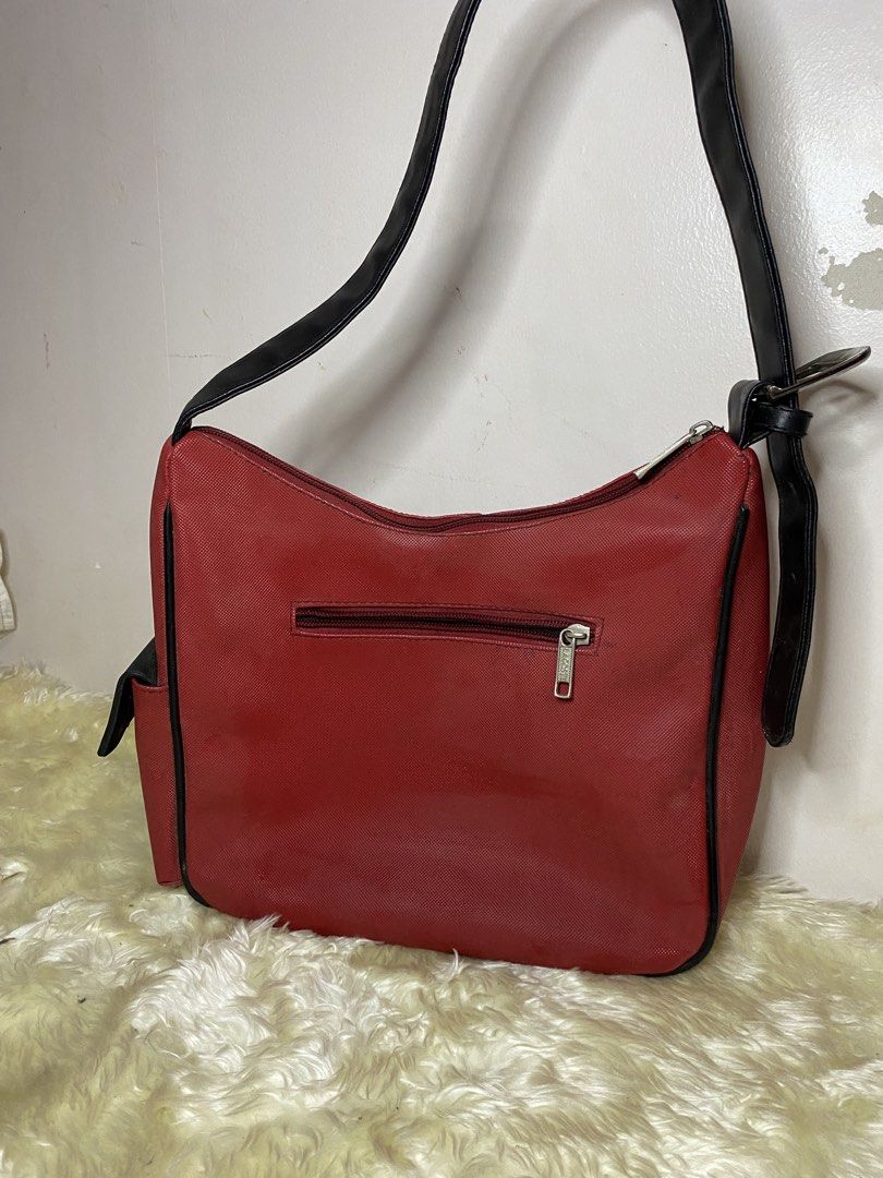 Lacoste Red Shoulder Bag (Category: Shoulder Bags) located in Manila. Submitted by ichiban_finds (Listing ID 1459394087, Image 3). Description: - Vibrant red Lacoste shoulder bag - Stylish black trim and strap - Secure top zipper closure - Convenient small zipper pocket on the back - Interior zippered pocket with iconic Lacoste logo - Ideal size for everyday use.