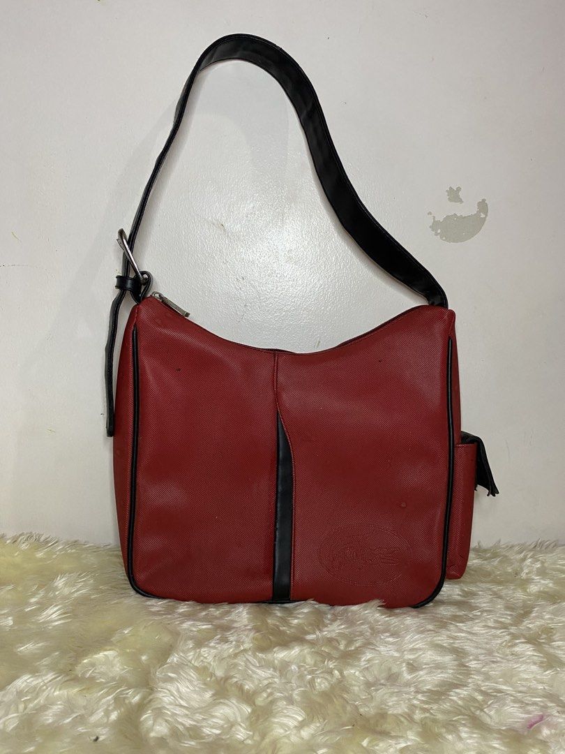Lacoste Red Shoulder Bag (Category: Shoulder Bags) located in Manila. Submitted by ichiban_finds (Listing ID 1459394087, Image 1). Description: - Vibrant red Lacoste shoulder bag - Stylish black trim and strap - Secure top zipper closure - Convenient small zipper pocket on the back - Interior zippered pocket with iconic Lacoste logo - Ideal size for everyday use.
