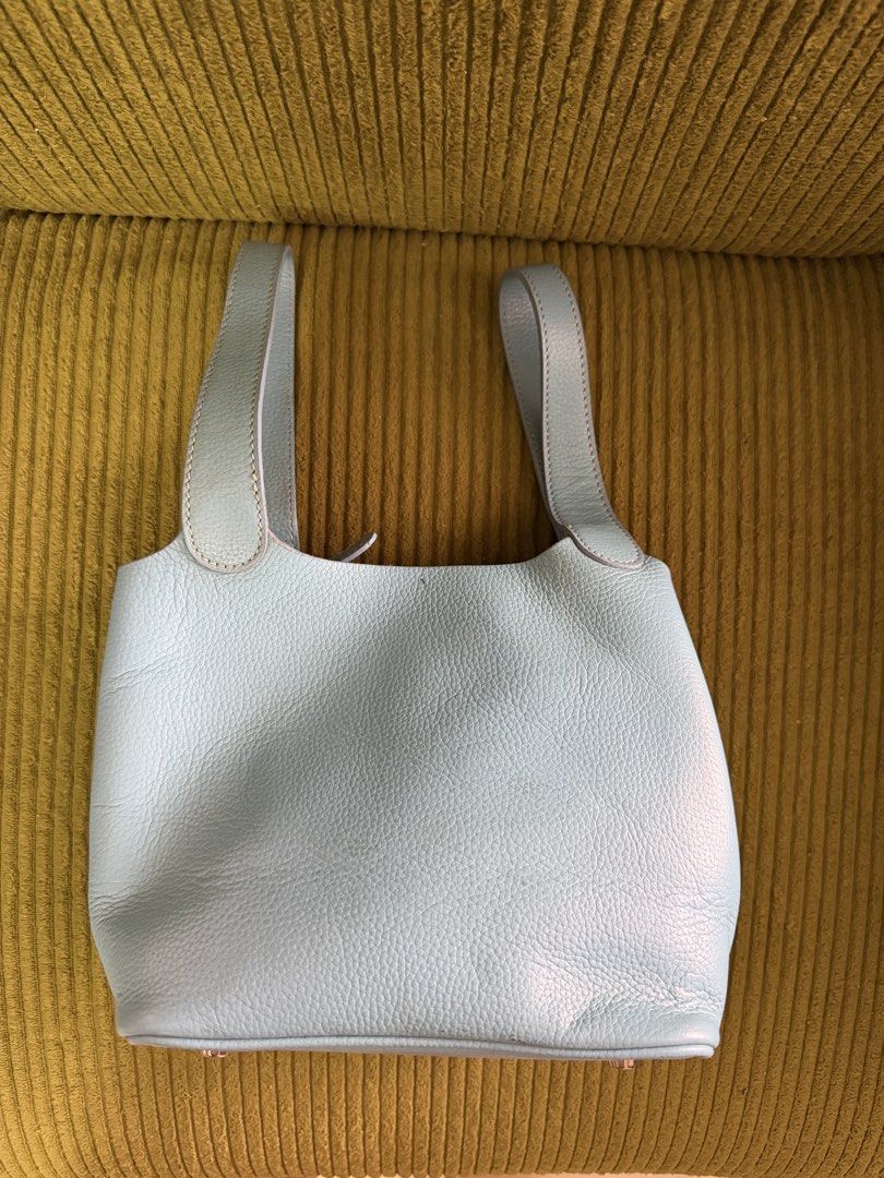 Light Blue Leather Bucket Bag with Top Handles (Category: Clutches) located in Manila. Submitted by lovelystuffmaycomeandgo (Listing ID 1459332997, Image 3). Description: - Cute light blue bucket bag - Color- Powder Blue - Width- 5 in, Length- 8 in, Height- 7 in, - Handle- 6 in dropdown - Textured leather material - Structured base with protective metal feet - Comfortable top handles for easy carrying - Secure strap closure inside - Ideal for eve