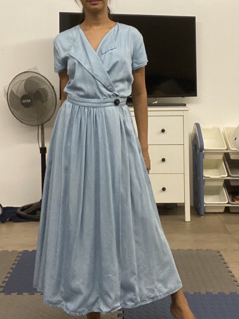 Light Blue Wrap Midi Dress (Category: Dresses) located in Santa Rosa. Submitted by hoardqueensdeclutter (Listing ID 1459366135, Image 1). Description: - Light blue midi dress - Flattering wrap front - Short sleeves - Cinched waist with dark button detail - Full, pleated skirt for lovely flow - Versatile: great for casual outings or dressing up.
