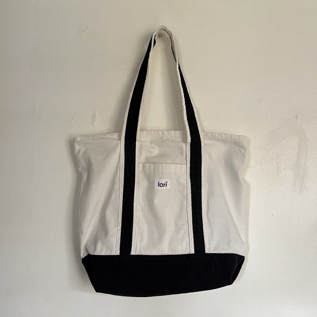 Lori Studio Canvas Tote Bag - White and Black (Category: Tote Bags) located in Las Pinas. Submitted by solfits (Listing ID 1459327142, Image 1). Description: - Classic white canvas tote bag - Black trim and handles - Convenient front pocket - Handy interior pocket - Simple and versatile design - Ideal for everyday use and carrying essentials.