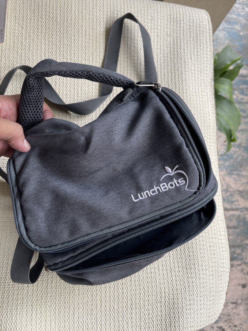 LunchBots Insulated Lunch Bag Grey (Category: Tote Bags) located in Mandaluyong City. Submitted by coolmeybab (Listing ID 1459352256, Image 2). Description: - Grey insulated lunch bag by LunchBots - Main zippered compartment - Smaller front pocket - Detachable shoulder strap included - Padded handle for comfort - Ideal for school or work lunches - Zippers are smooth and functional - Bag is clean inside and out.