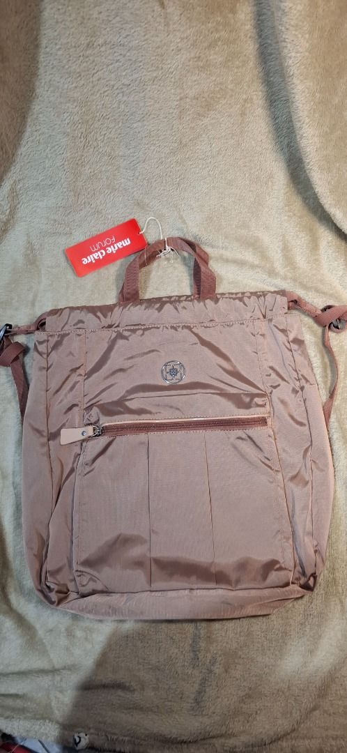 Lux Draw string/ backpack (Category: Luxury Bags & Wallets) located in General Santos City (Dadiangas). Submitted by sloane.sloane (Listing ID 1459370740, Image 2). Description: Brown nylon convertible tote backpack featuring a front vertical zipper pocket and a branded label reading "marie claire Forum"..